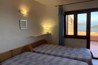 Letto o letti in una camera di SAN TEODORO PUNTA EST GIARDINO VISTA MARe