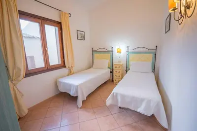 Letto o letti in una camera di residence baia sant anna con piscina