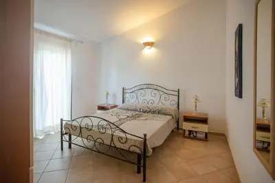 Letto o letti in una camera di Villetta con Piscina - BUDONI