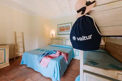 Letto o letti in una camera di Valtur Baia dei Pini